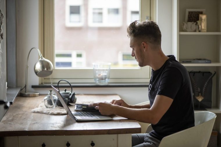 Young man at a computer on a desk with a cup and a lamp. ChatGPT Secrets: How to Get the Most Out of Artificial Intelligence